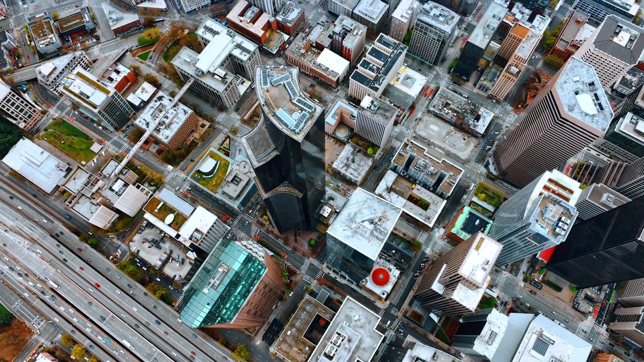 Mange biler kører forbi den brede flersporede motorvej i Seattles centrum, Washington, USA. Udsigt over tagtoppene på de forskellige bygninger i centrum.
