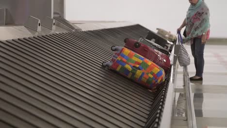 woman approaching baggage reclaim conveyor