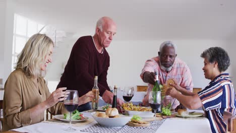 Verschiedene-ältere-Paare-Sitzen-An-Einem-Tisch,-Trinken-Wein-Und-Essen-Zu-Abend