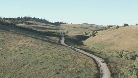 View-from-above-as-solitary-truck-drives-on-winding-dirt-road-through-hills