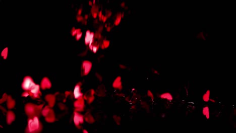 animation of red kaleidoscope shapes and red hearts falling on black background