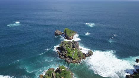 aerial view over a cliff on the island of timang with a view of the coral islands in the surf of the sea