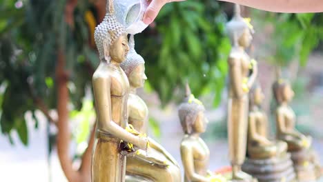 pouring water over buddha statues in sequence