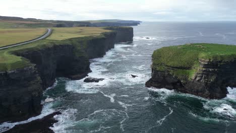 Acantilados-De-Kilkee-En-Irlanda-Con-Olas-Rompiendo-Contra-La-Escarpada-Costa,-Serena-Belleza-Natural,-Vista-Aérea