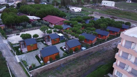 aerial above wooden rental homes and hotel building in albanian town, golem.