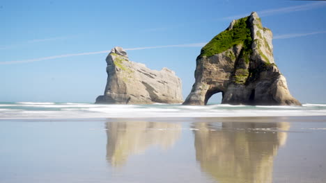 timelapse of rippling water at the touristic rocks in the ocean on a sunny day