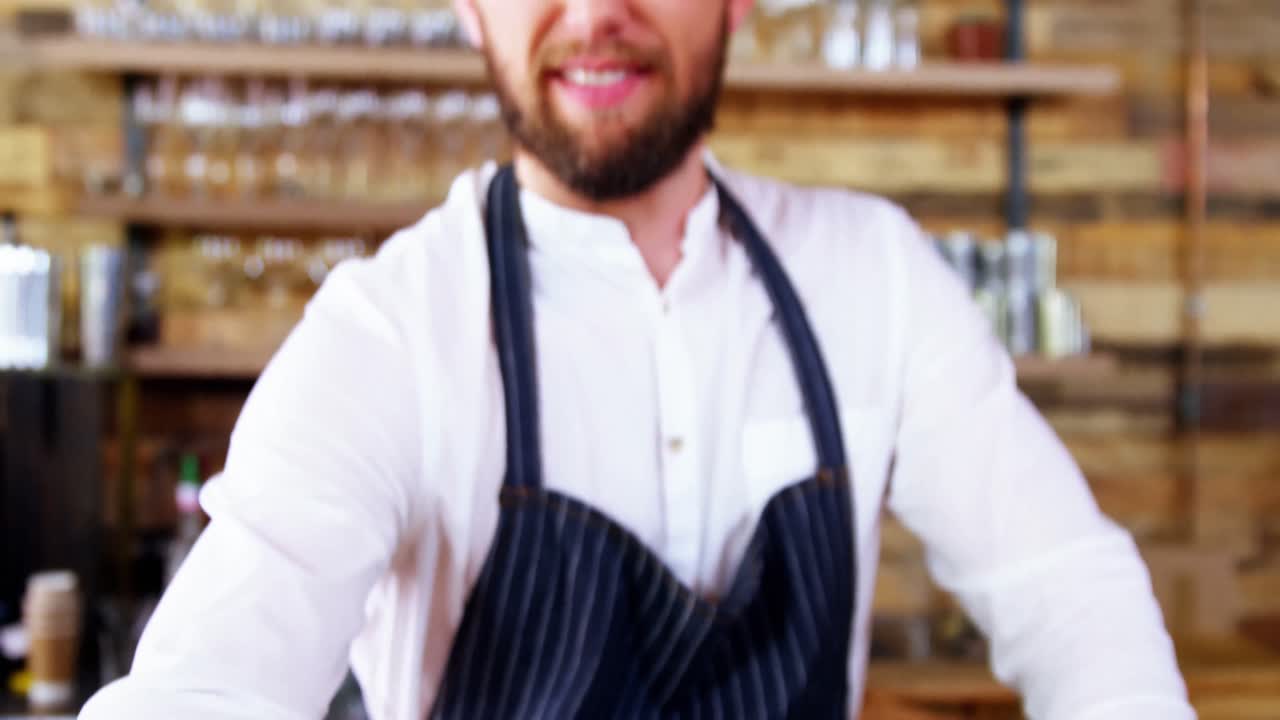 Porträt eines Kellners, der Kaffee an der Theke serviert