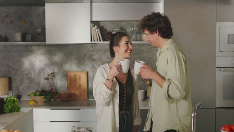 happy couple enjoying morning coffee in a modern kitchen