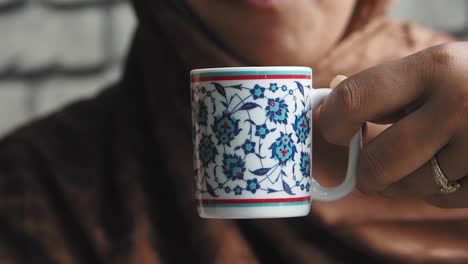 close-up of a hand holding a cup of turkish coffee