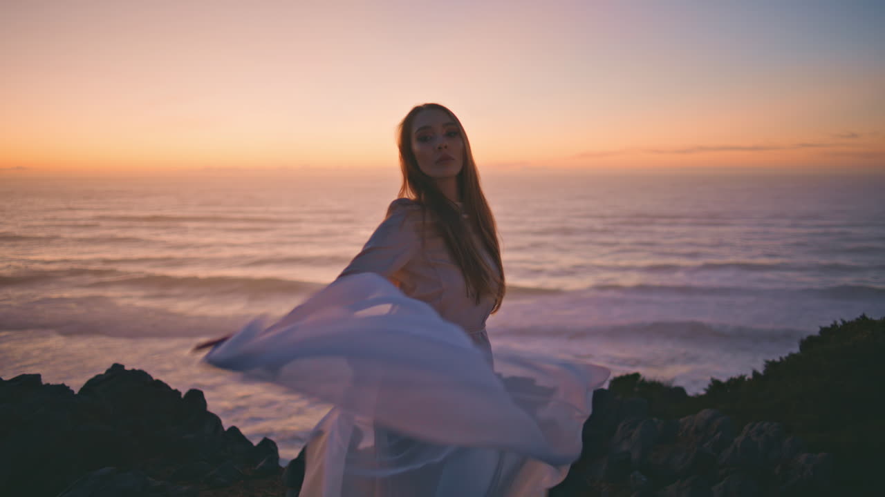 Sensual girl waving cloth performing contemporary dance in summer sunset hill