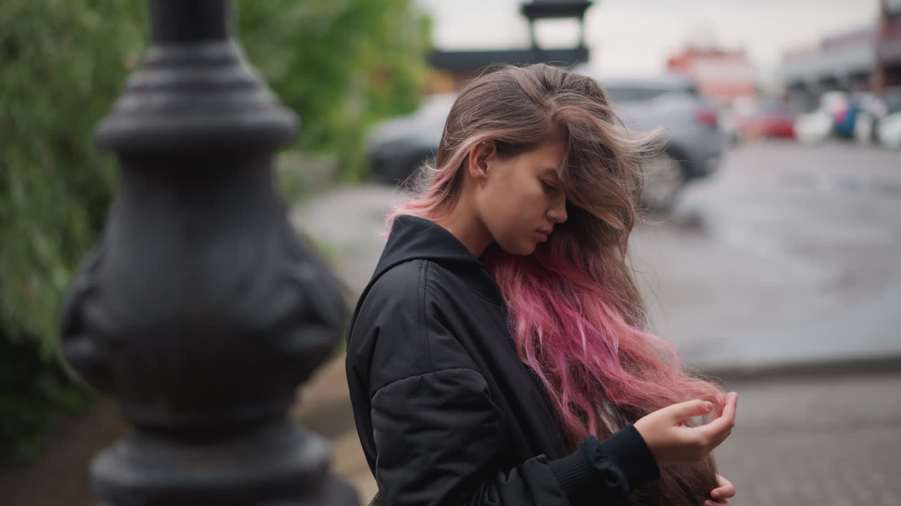 Donna pensierosa sotto la pioggia. Femmina con i capelli bagnati sotto un cielo tempestoso. Donna in piedi sotto la pioggia con uno sguardo contemplativo. Giovane donna con i capelli umidi in un paesaggio urbano piovoso che mostra un'espressione pensierosa.