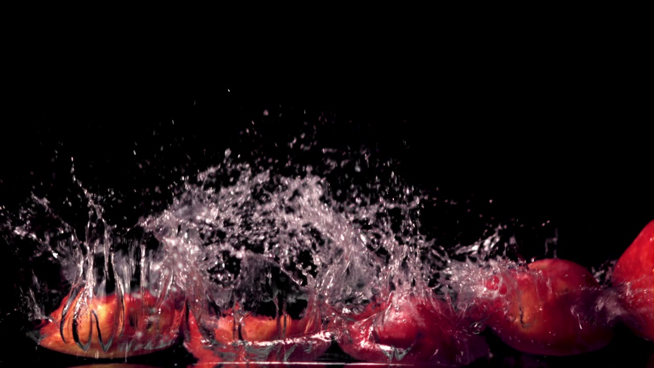 Red Apples Splashing into Water in Super Slow Motion