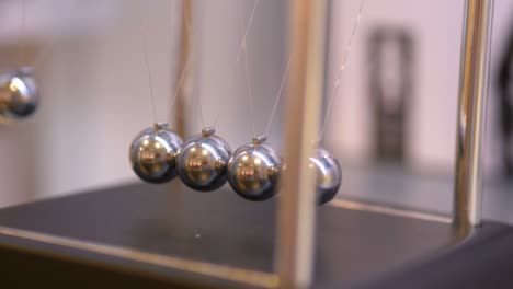 pendulum with swinging metal spheres in 4k slow motion 60fps