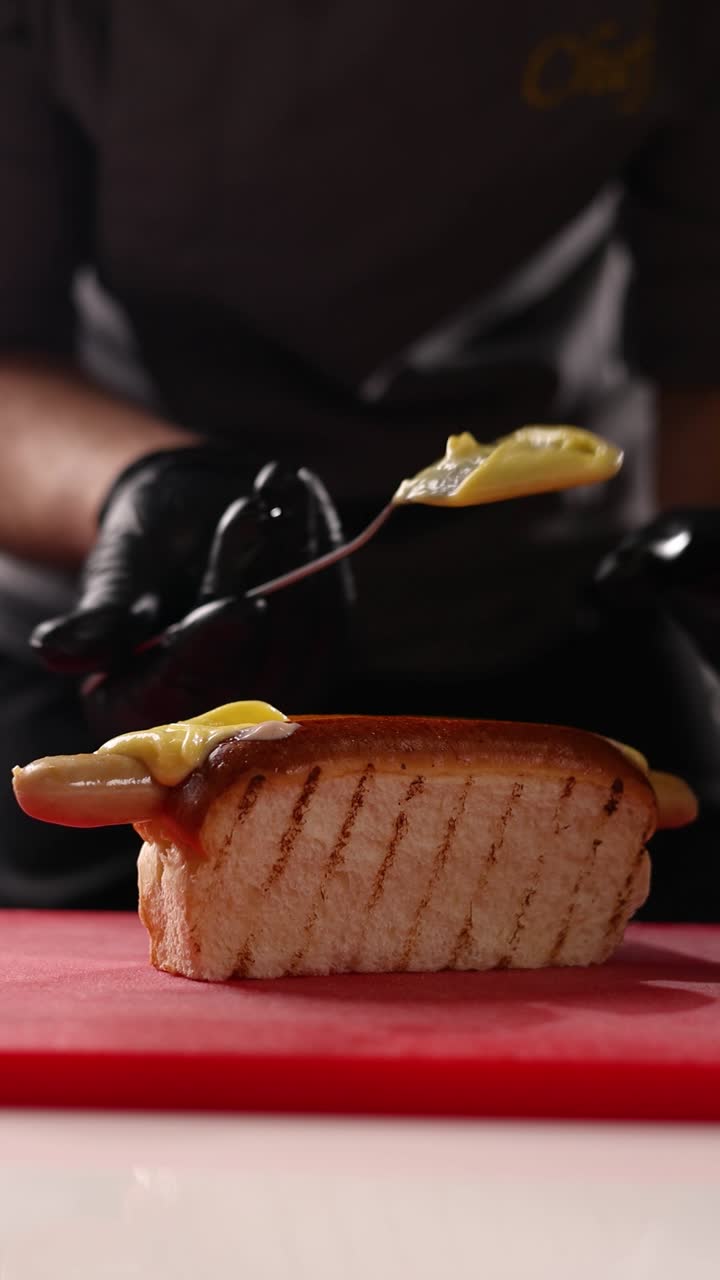 el chef preparando un perrito caliente