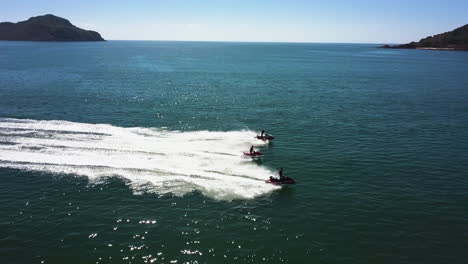 Tracking-shot-of-jet-skis-sailing-between-two-islands