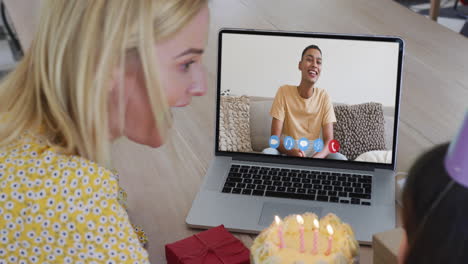 caucasian mother and daughter celebrating birthday on video call on laptop at home