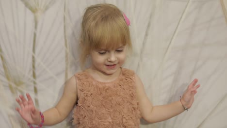 Happy-three-years-old-girl-make-faces-and-dancing.-Cute-blonde-child