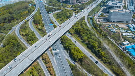 Bird's-view-of-multi-level-junction-road-lands-with-moving-cars-traffic-of-modern-highway-with-overpass-bridge-at-countryside