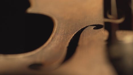 primer plano de violín antiguo, cambios de luz dramáticos sobre el instrumento, secuencias de video de música sinfónica clásica