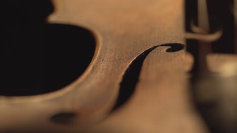 close up of old violin, dramatic light changes over the instrument , classical symphony music video footage