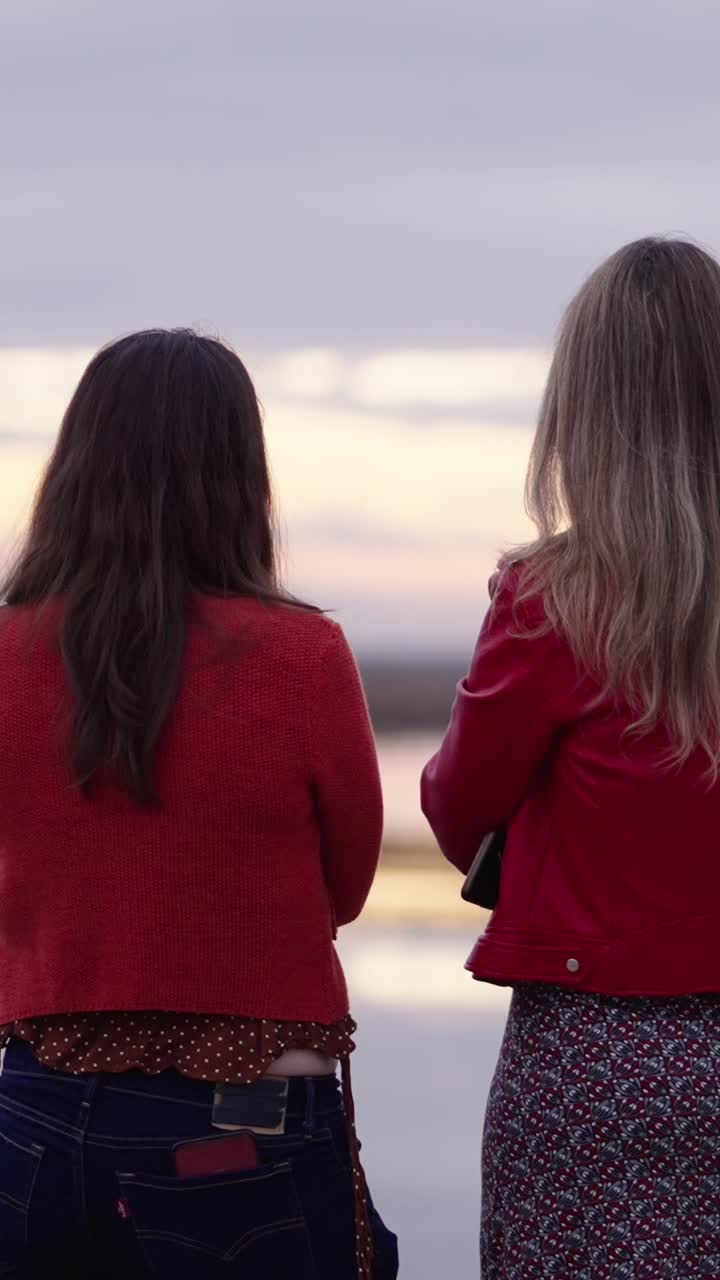 두 여인이 야외에서 대화를 나누고 있다