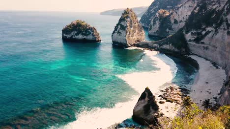 beautiful 4k tropical beach aerial - a bird's eye view of ocean waves crashing against an empty beach from above.
