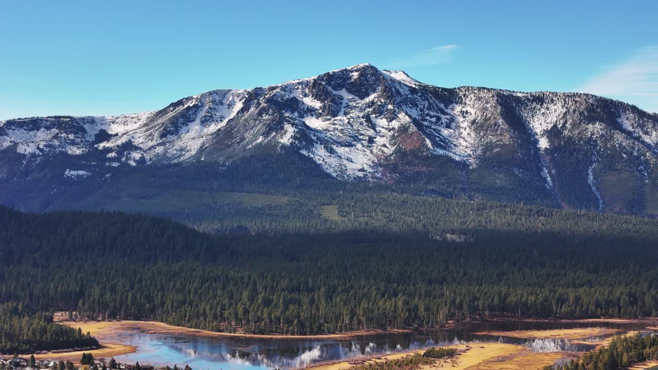 Aerial view of snow capped Mount Tallac in South Lake Tahoe with forest and water