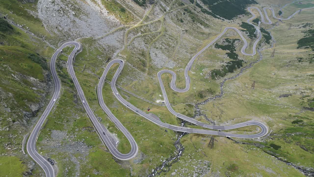 los coches conducen transfagarasan carretera de montaña en los cárpatos, rumania, europa - 4k aéreo