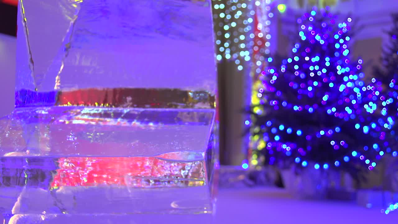 Static bokeh shot of an ice star with an out-of-focus Christmas tree and lights