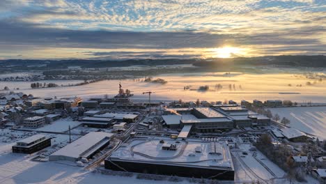 aerial drone footage of a beautiful sunrise in switzerland, november 2024. snow-covered village and landscape with deep snow, creating a stunning winter scene.