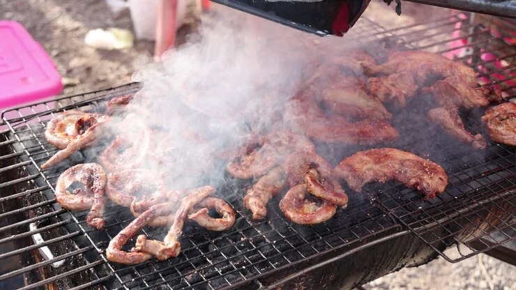 Tentacoli di polpo alla griglia, con fumo che sale costantemente