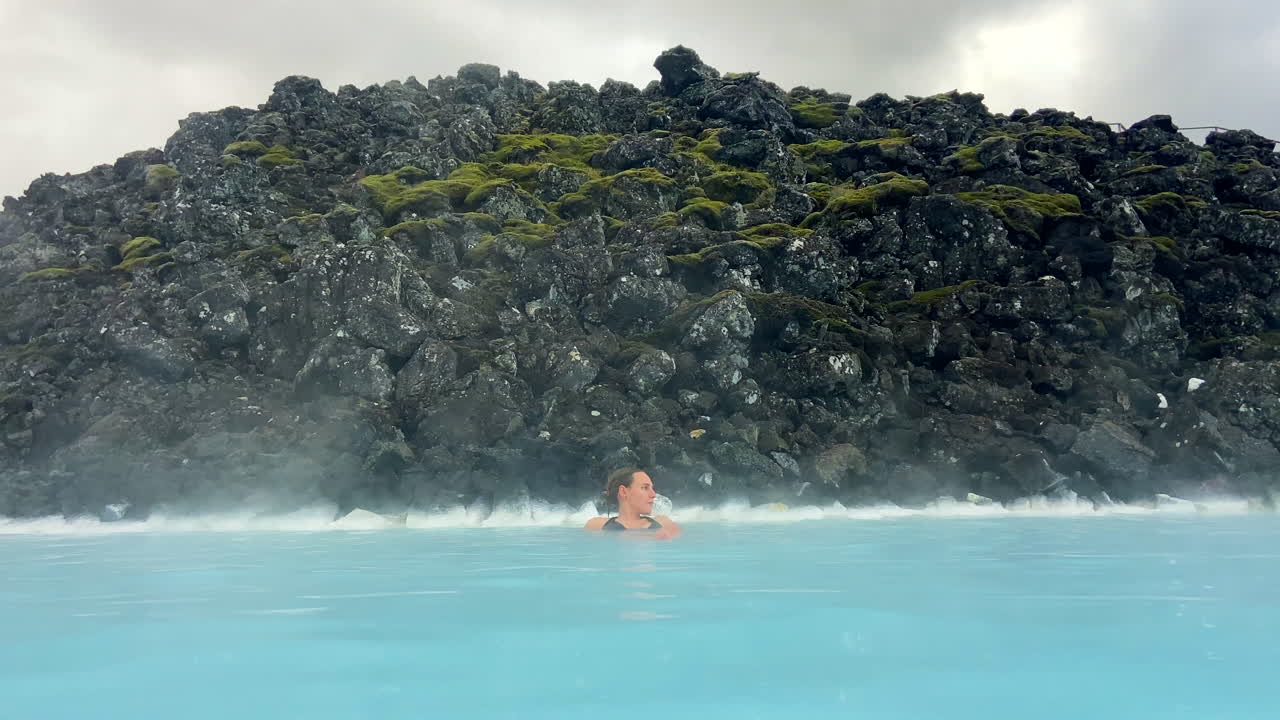 Caucasian woman relaxing in Blue Lagoon outdoor thermal spa in Iceland