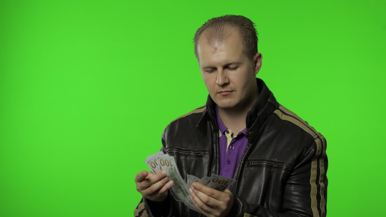 hombre empleado en chaqueta cuenta billetes de dólar en efectivo y pone dinero en su bolsillo. dinero ingresos en efectivo