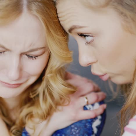 young woman comforts and supports his girlfriend who is upset and crying 2