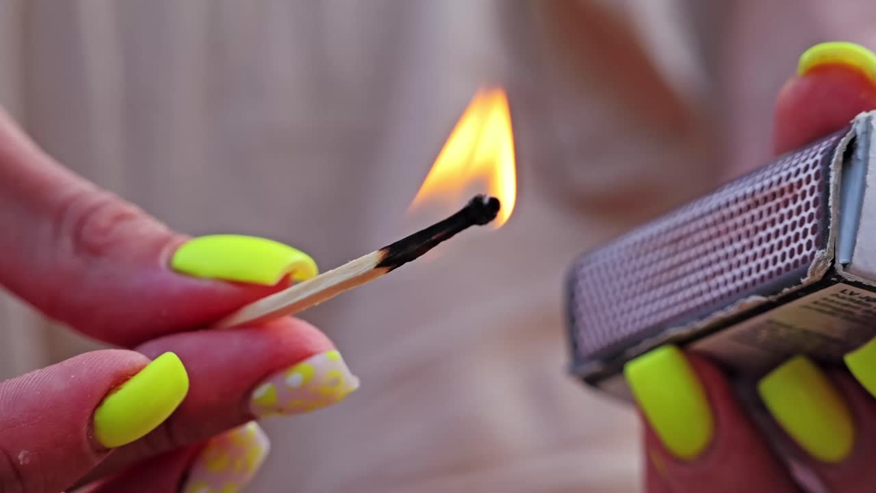 Steady flame on match captured in slow motion, fingers gently holding it