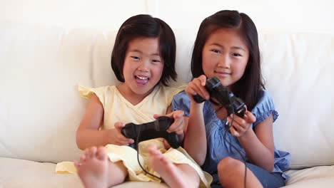 two sisters playing a games console together