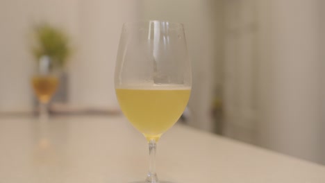 a glass of kombucha drink on white bar table