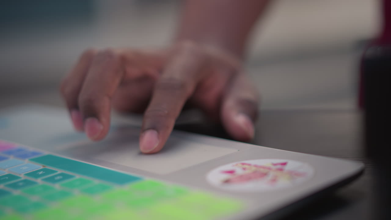 Closeup black DJ fingers on pad controller mixing live, colorful RGB pads and stickered casing, fingers tapping loops and faders, beat sequencing workflow, street musician energy in outdoor afternoon
