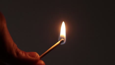 persona encendiendo una cerilla en la oscuridad
