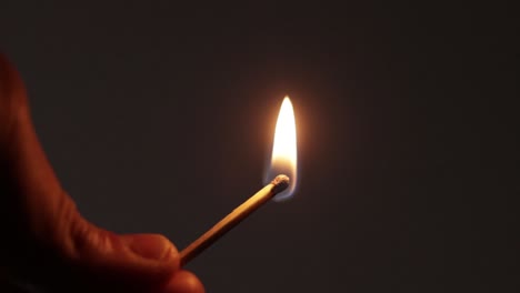 person striking a match in darkness