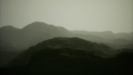 mountainous landscape shrouded in mist under soft lighting conditions