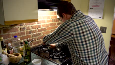 domesticated white male cleans the kitchen and stove