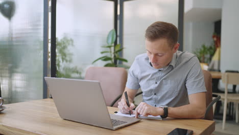 Hispanic-latin-man-college-student-using-laptop-computer-watching-distance-online-learning-seminar-class-remote-university-webinar-or-having-virtual-classroom-meeting-in-university-creative-space.