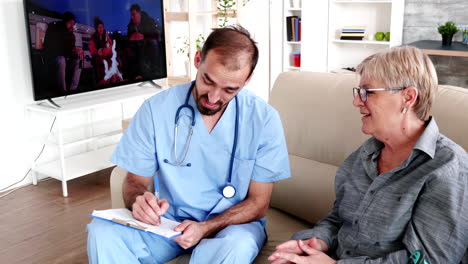 Male-nurse-talking-with-old-lady-patient-in-retirement-home