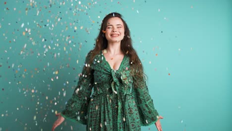 cheerful young woman dancing under falling confetti