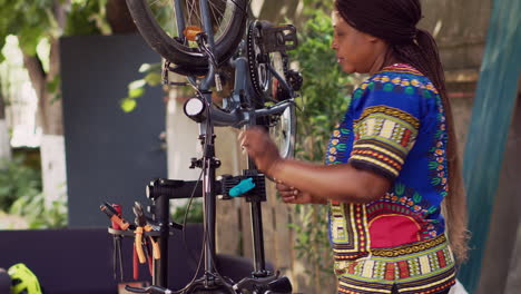 mujer ajustando una rueda de bicicleta dañada