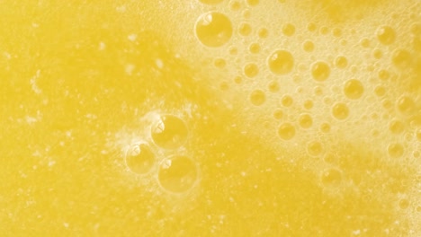 closeup shot of bubbles forming and fizzing from orange water