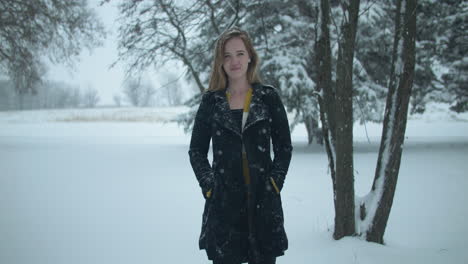 Happy-woman-outside-in-slow-motion-winter-snow-as-snowflakes-fall-in-cinematic-slow-motion