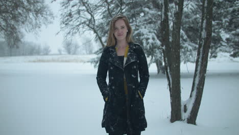 happy woman outside in slow motion winter snow as snowflakes fall in cinematic slow motion