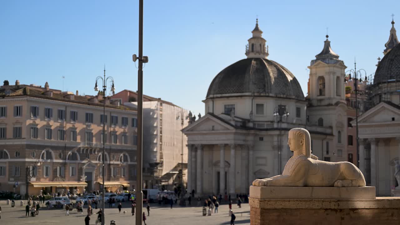 Et bredt perspektiv av den historiske Piazza del Popolo i Roma, med den sentrale egyptiske obelisken, de to barokkirkene og de neoklassiske fontenene under en klar himmel